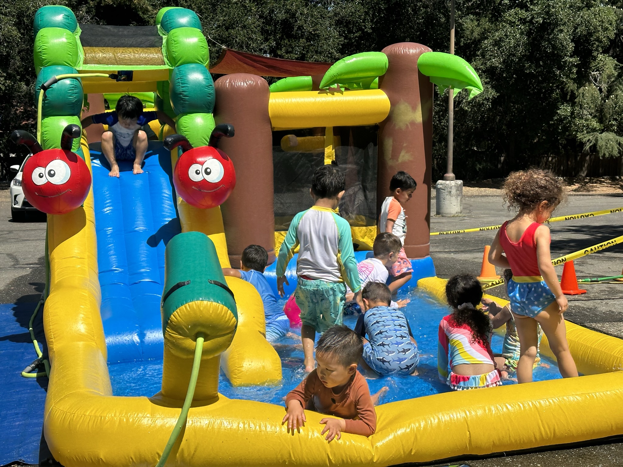 Children playing on an inflatable water slide at Butterflies Academy summer camp